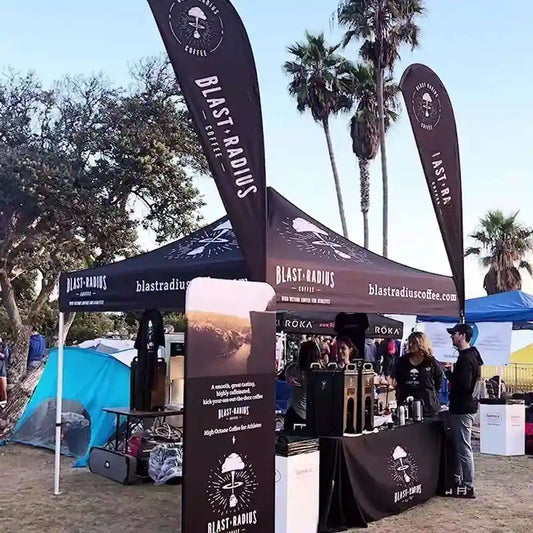Pyrasun custom event tent with printed flags and table cover, high-visibility branded exhibition setup.