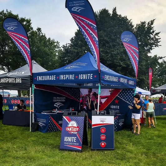 Pyrasun custom event tent for non-profit organizations, high-visibility branded exhibition setup with feather flags.